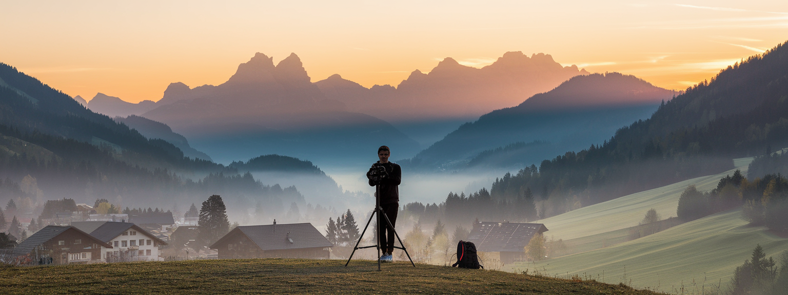 Traveler capturing a scenic mountain view using essential tips for travel photography.