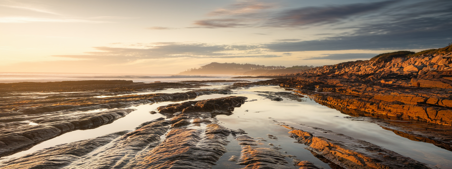 Photographer with tripod framing a sunrise mountain vista for landscape photography